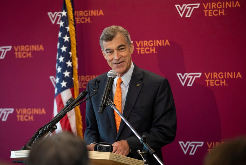 Man standing in front of Virginia Tech backdrop