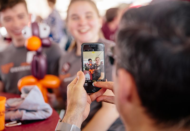 A Hokie takes a picture with a smart phone