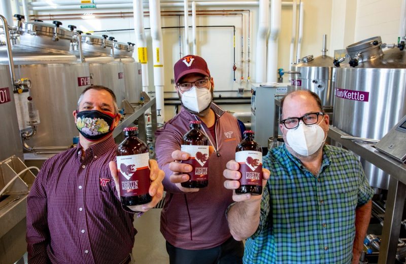 group of masked people holding Fightin' Hokies Lager