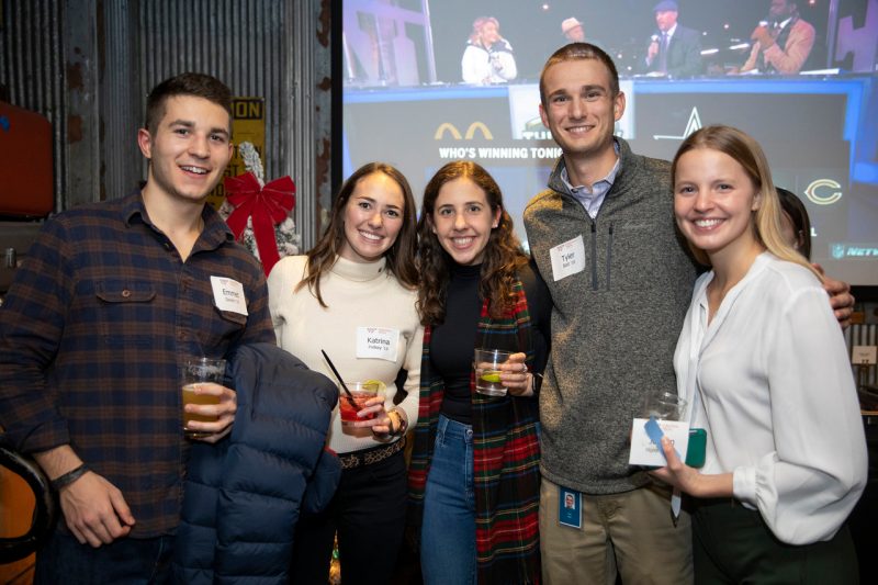 group of young alumni smiling with drinks