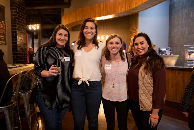 young female alumni smiling with drinks