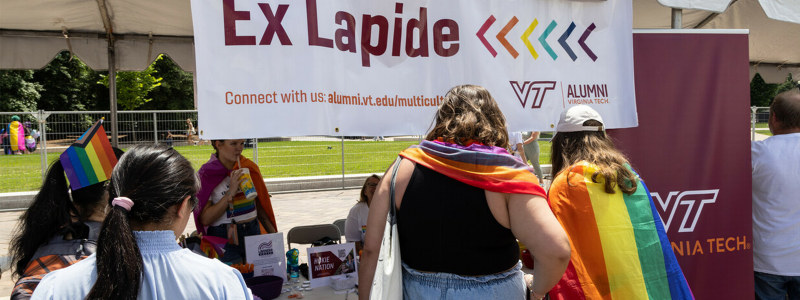 Ex Lapide banner and people at a table