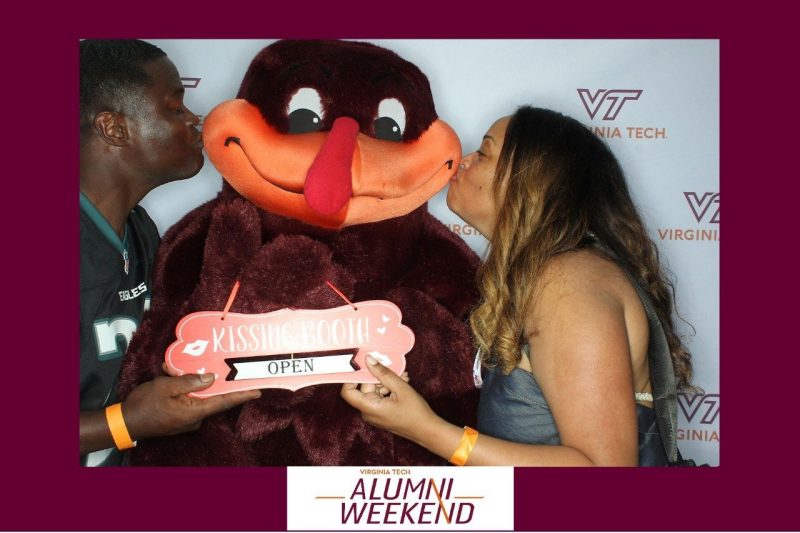 Alumni in photo booth with Hokie Bird during Alumni Weekend