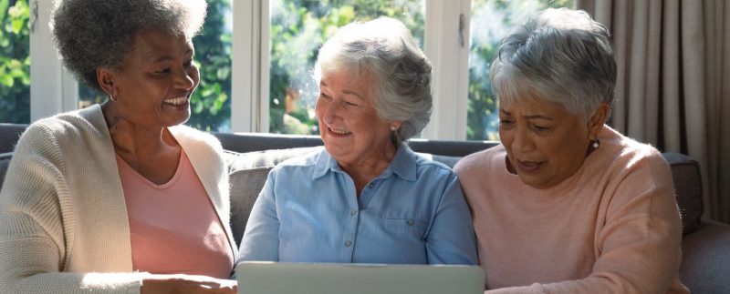 Three older women looking at a laptop