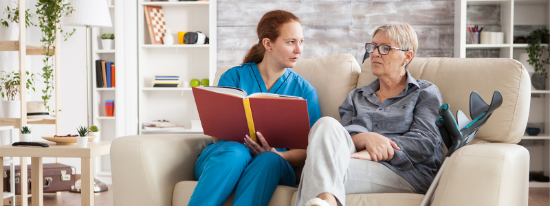 A nurse reading to an older woman
