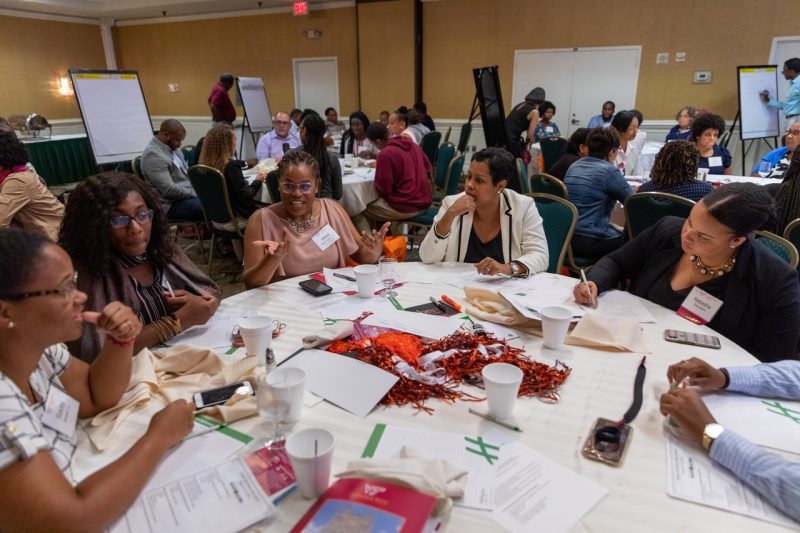 A group of alumni talk around a table at the Black Alumni Summit