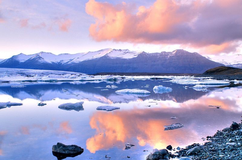 glacier with sun setting behind it