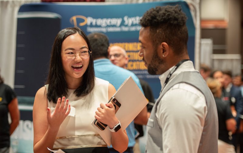 two students speaking at a career fair