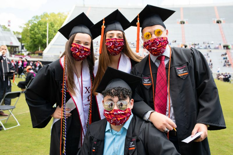 students wearing masks in graduation robes
